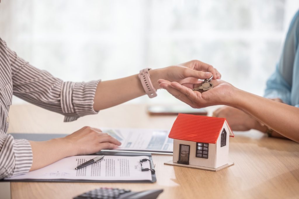 image of house and mortgage rates with house key changing hands