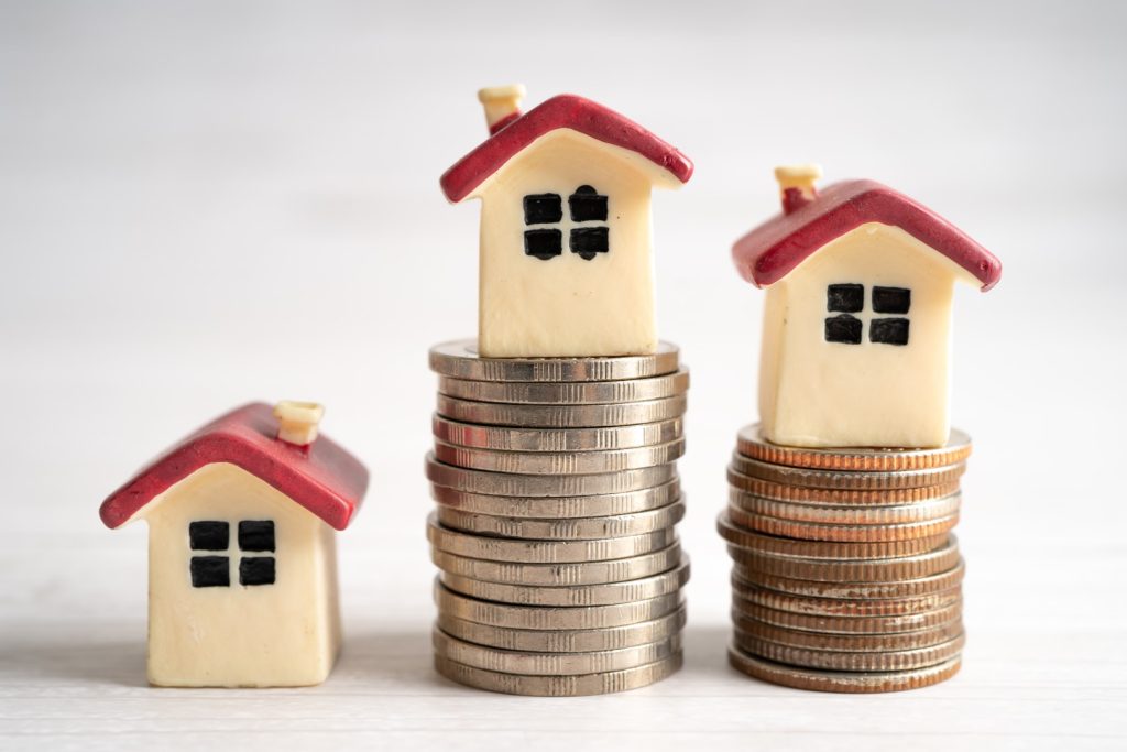 image of houses atop money to show how to build equity with fixed vs adjustable mortgages